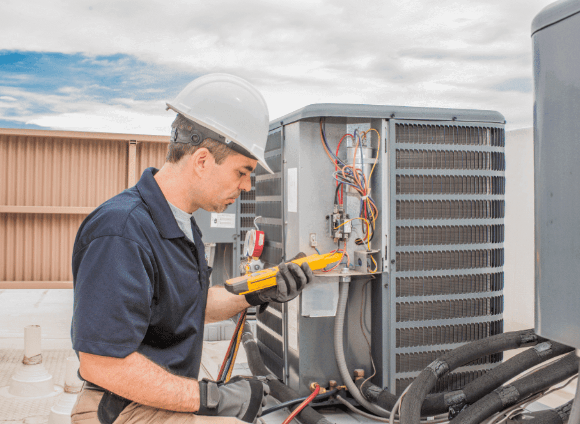 Certified HVAC technician performing commercial air conditioning repair and maintenance service on rooftop unit in Dubai UAE