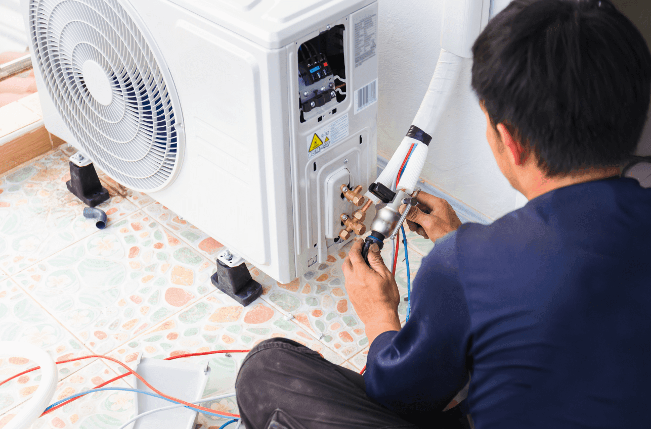 HVAC technician diagnosing and repairing commercial air conditioning unit fault in Dubai office building
